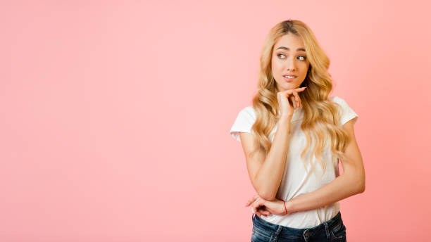 istock Pensive woman looking aside at free space and touching chin 1205272117
