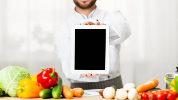 istock Unrecognizable Male Chef Showing Blank Tablet Screen Standing In Kitchen 1205272159