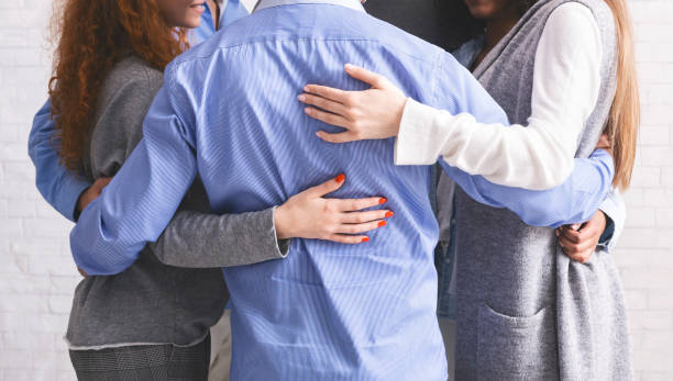 istock Group of diverce people standing in circle and embracing each other 1205272334