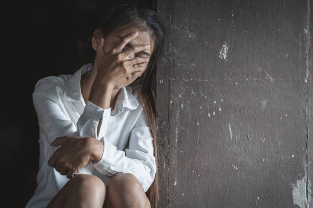 istock Depressed Upset Woman in a dark room 1205272909