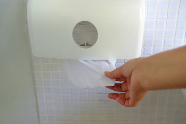 istock Woman hand taking white paper from holder on wall. 1205272930