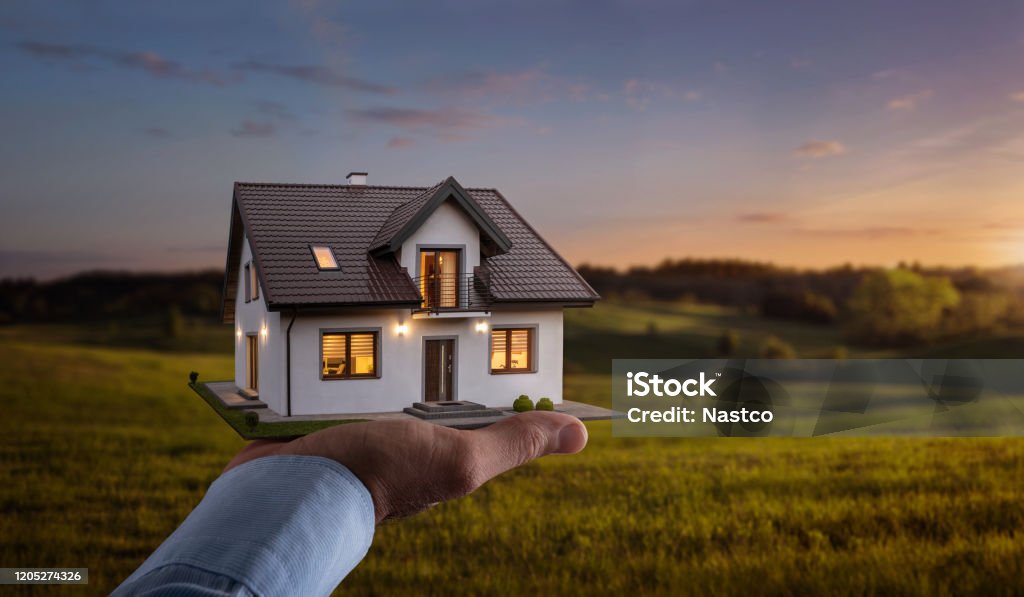Male hand showing, offering a new dream house at the empty field with copy space Concept of buying or building a new home. Male hand showing, offering a new dream house at the empty field with copy space House Stock Photo