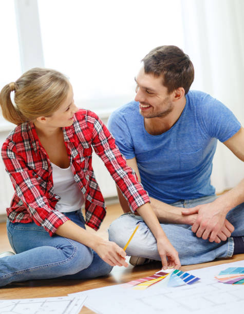 istock smiling couple looking at color samples at home 1205274975