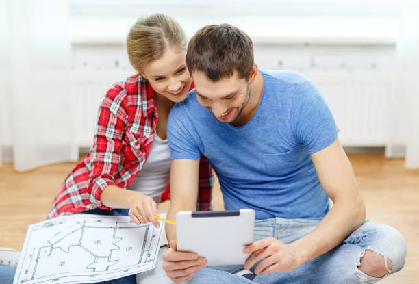istock smiling couple looking at tablet pc at home 1205275101