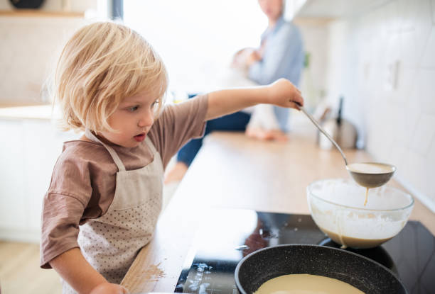 istock A small boy helping indoors in kitchen with making pancakes. 1205275183