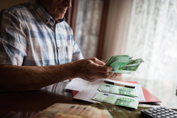 istock Senior man's hands holding Euro banknote 1205275807