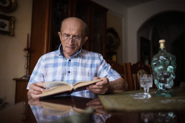 istock Old man wearing eyeglasses when reading a book 1205275999