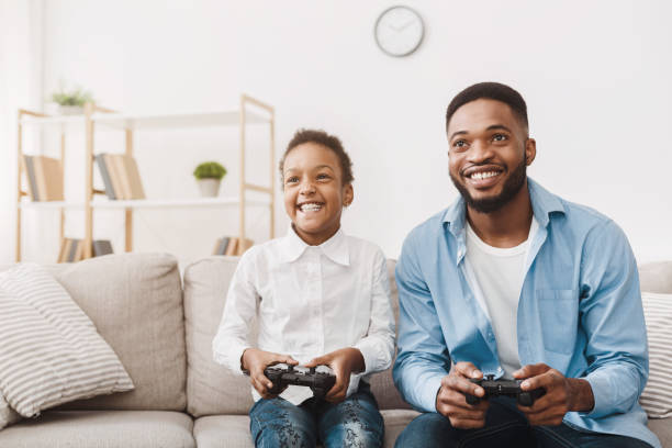 istock Happy afro dad enjoying video game with his cute daughter 1205277975