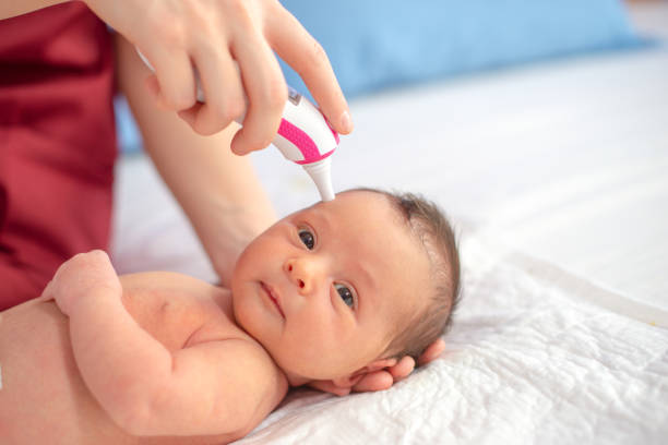 istock Doctor with digital thermometer checking newborn temperature 1205279876