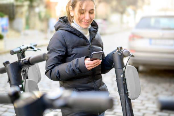 istock Woman using smartphone and renting modern electric scooter 1205280014