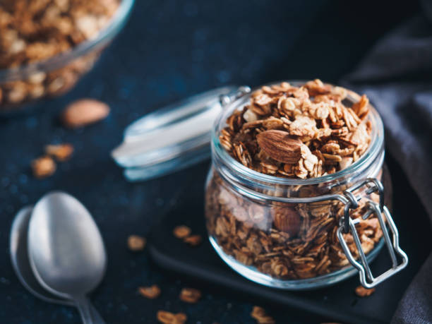 domowa granola w szklanym słoiku na ciemnym stole - jar oatmeal granola glass zdjęcia i obrazy z banku zdjęć