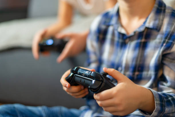 istock Closeup on kids hands playing console games 1205281417