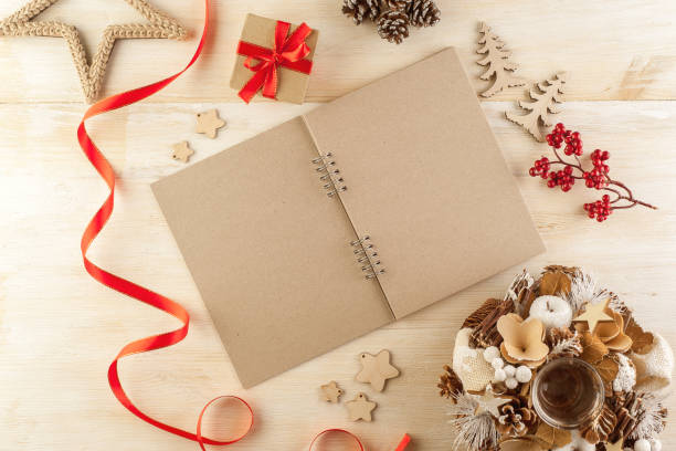 istock Open notebook in dark paper on a wooden table surrounded by handmade Christmas decorations 1205281448