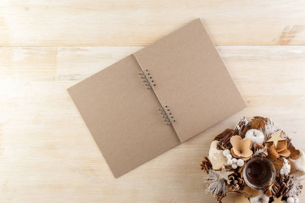 istock Open notebook in dark paper on a wooden table surrounded by handmade Christmas decorations 1205281460