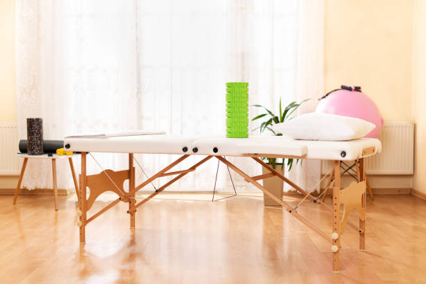 interior of a massage or physical therapy treatment room with examination table. - massage table imagens e fotografias de stock