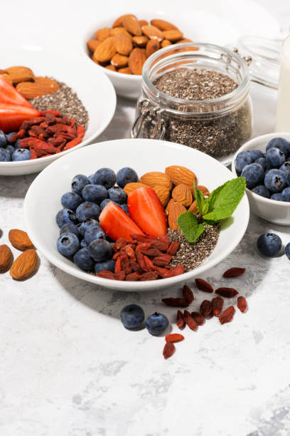 istock chia seeds, fresh berries and nuts for a healthy breakfast, vertical 1205283637