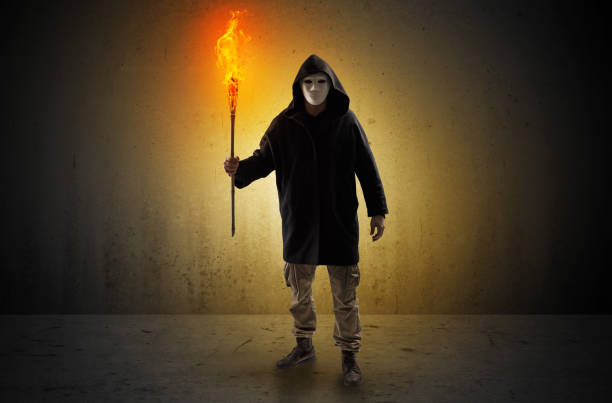 Ugly scary man with burning flambeau walking in an empty space