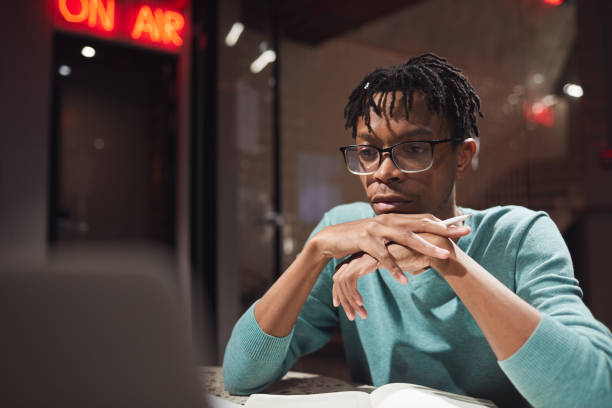 istock Young African-American Man Using Laptop in Dark 1205285114