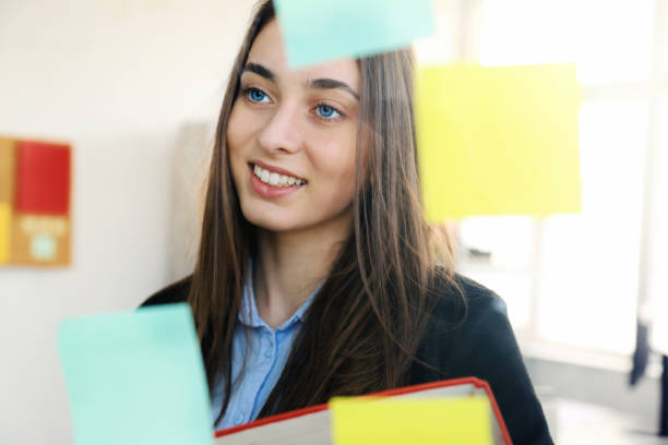 istock Beautiful business woman looking at sticky notes 1205285620