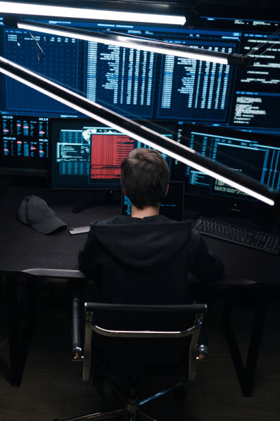 istock Top view of a computer hacker coding on laptop on a background of monitors. 1205286113