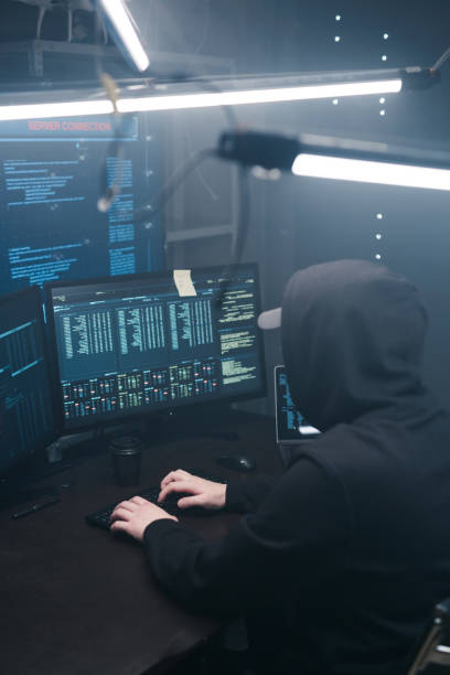 istock Top view of a computer hacker coding on laptop on a background of monitors. 1205287297