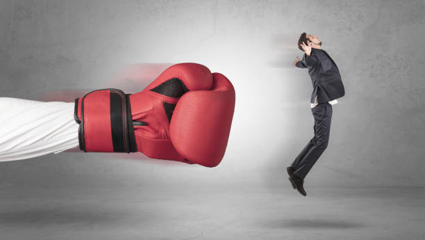 istock Businessman gets a hit from a giant hand 1205288802