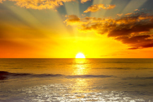 Majestic bright sunrise over ocean Majestic bright sunrise over ocean and light waves on blue sea. sunrise stock pictures, royalty-free photos & images