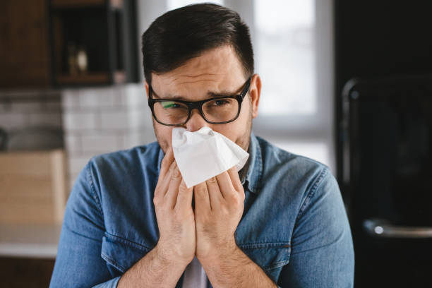 istock Young man with cold, flu, running nose at home 1205291176