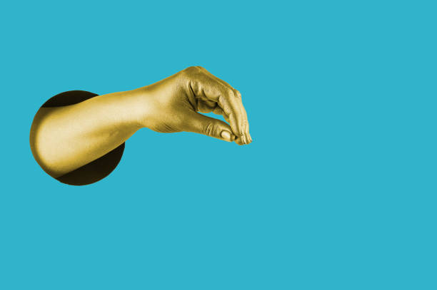 istock Hand painted in gold shows different gestures and symbols from the hole on a bright blue paper background. 1205291476
