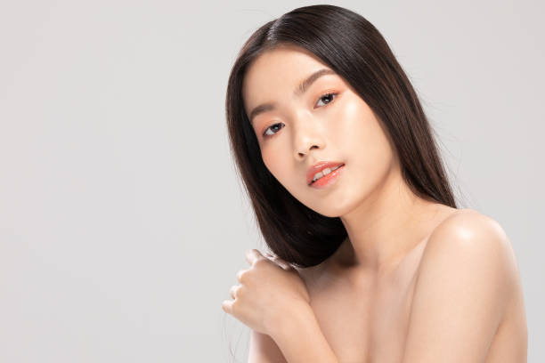 istock Beautiful Young Asian Woman Looking While Touching Shoulder feeling so happy and cheerful with healthy Clean and Fresh skin,isolated on white background,Beauty Cosmetology Concept 1205291555