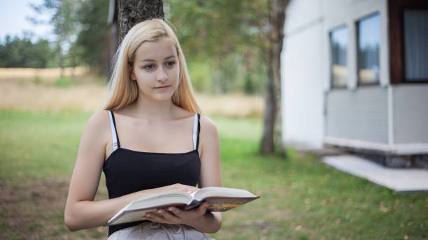 Young woman reading book and relaxing in nature