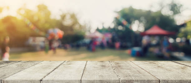 istock Empty wood table and defocused bokeh and blur background of garden trees in sunlight, display montage for product. 1205294564