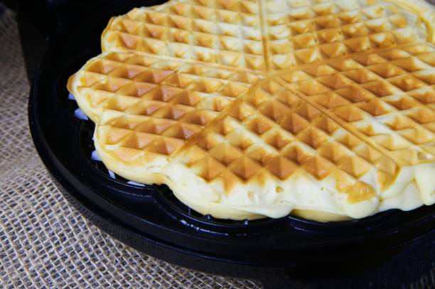 istock Close up of fresh made waffle on iron 1205295748