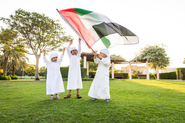 Group of middle eastern kids in Dubai Group of middle-eastern kids wearing white kandora playing in a park in Dubai - Happy group of friends having fun outdoors in the UAE emirati culture photos stock pictures, royalty-free photos & images