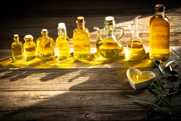 istock Olive oil bottles in a row on rustic wooden table 1205303091