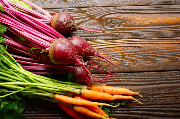 istock Fresh organic beetroots and carrots on kitchen wooden rustic table close up view 1205303377