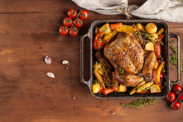 istock Baked whole chicken with vegetables. Table setting with Christmas decorations. Rustic style. 1205303654