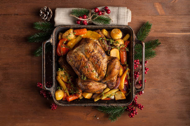 Baked whole chicken with vegetables. Table setting with Christmas decorations. Rustic style. stock photo