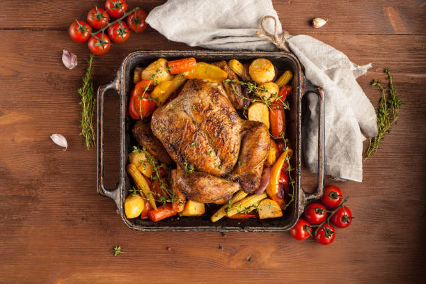 istock Baked whole chicken with vegetables. Table setting with Christmas decorations. Rustic style. 1205304128