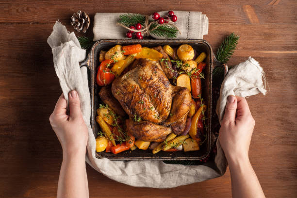 istock Baked whole chicken with vegetables. Table setting with Christmas decorations. Rustic style. 1205304618