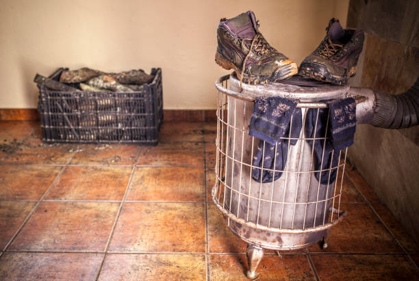 Wet used boots and socks drying over firewood stove in Spain, Extremadura, Montijo