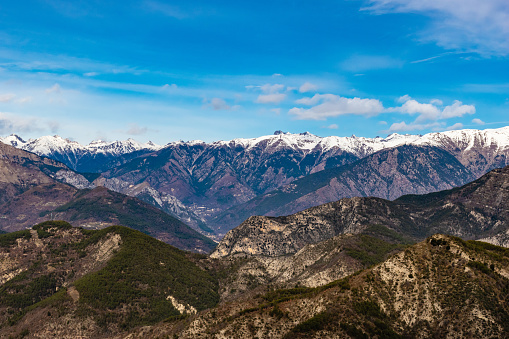 Beautiful captivating landscape of the layered snowy French Alps mountain range in Alpes-Maritimes in the afternoon during a sunny day