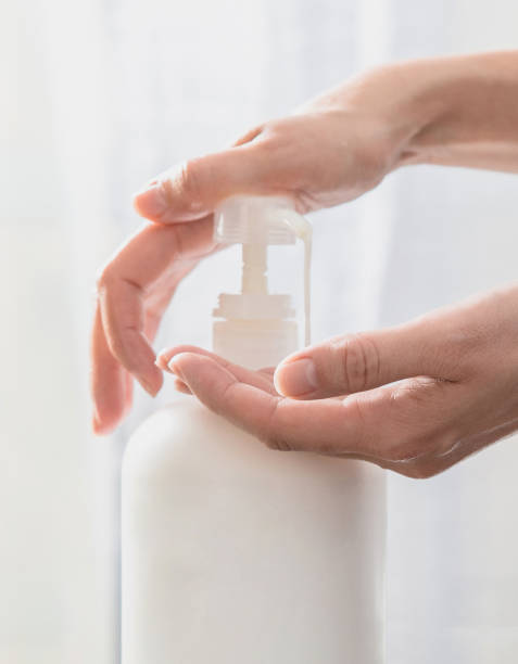 istock Woman hands pushing pump plastic soap bottle on white background 1205305682