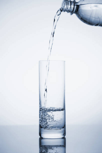 istock Clear mineral water splashes in a glass with ice. Fluid in motion. 1205306230