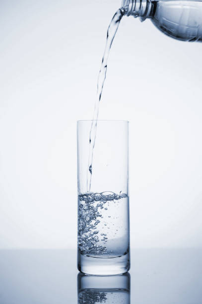 istock Clear mineral water splashes in a glass with ice. Fluid in motion. 1205306238