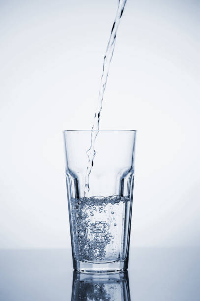 istock Clear mineral water splashes in a glass with ice. Fluid in motion. 1205306340