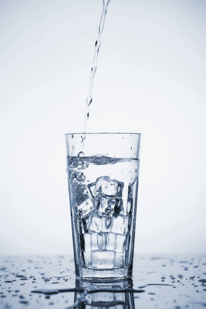 istock Clear mineral water splashes in a glass with ice. Fluid in motion. 1205306520