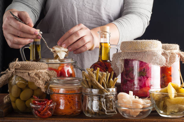 frau macht hausgemachte konserven eingelegt und fermentierte gemüse für die langfristige lagerung. erhaltung von saisonal empfändendem gemüse und vitaminen. - jar canning food preserves stock-fotos und bilder