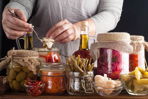 Woman makes homemade canned pickled and fermented vegetables for long-term storage. Preservation of seasonal vegetables and vitamins. Vegetarian food.