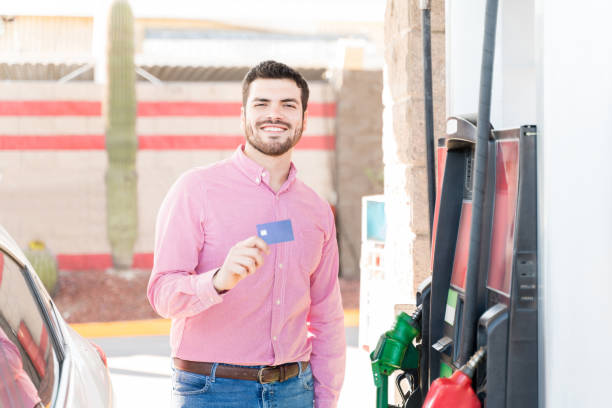 istock Smiling Customer Holding Credit Card At Gas Station 1205310188